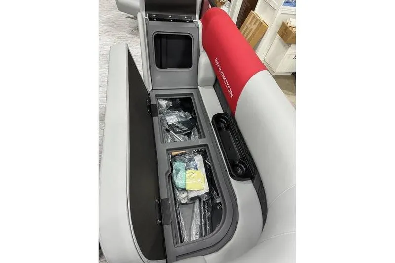 Slide: The Image of 2026 Bennington 22 SSR Quad Bench with storage compartment open, showcasing interior features. - 14