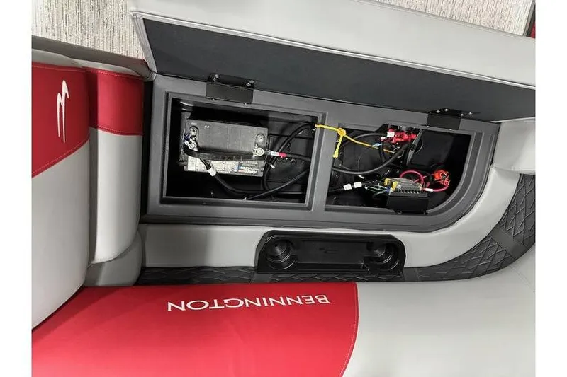 Slide: The Image of 2026 Bennington 22 SSR Quad Bench storage compartment with battery and wiring. - 22