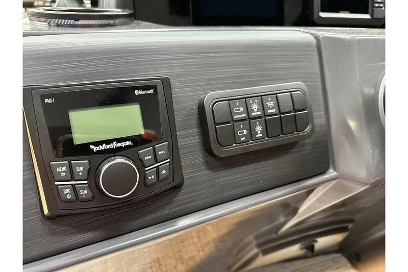 Slide: The Image of 2026 Bennington 22 SSR Quad Bench dashboard with Rockford Fosgate Bluetooth stereo and control panel. - 28