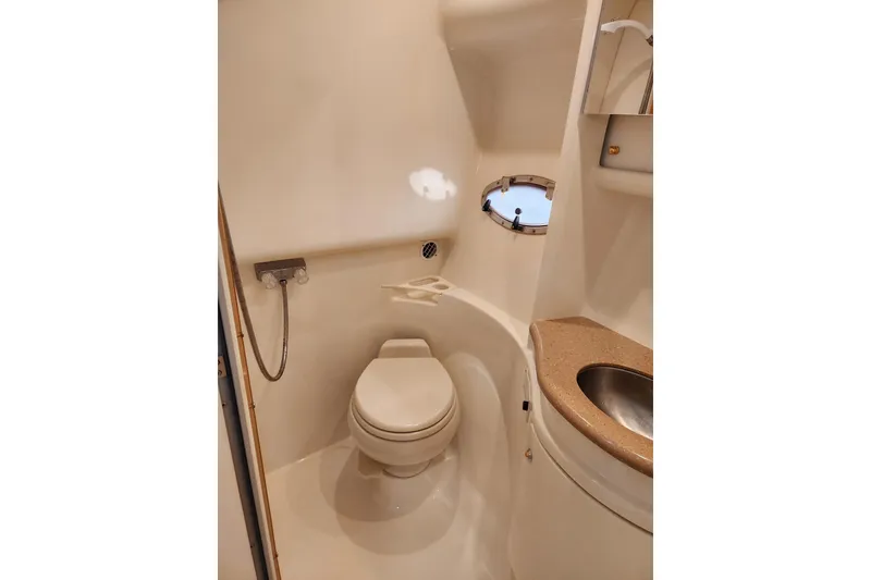 Slide: The Image of 2004 Formula 37 Performance Cruiser bathroom with toilet, sink, and porthole window. - 6