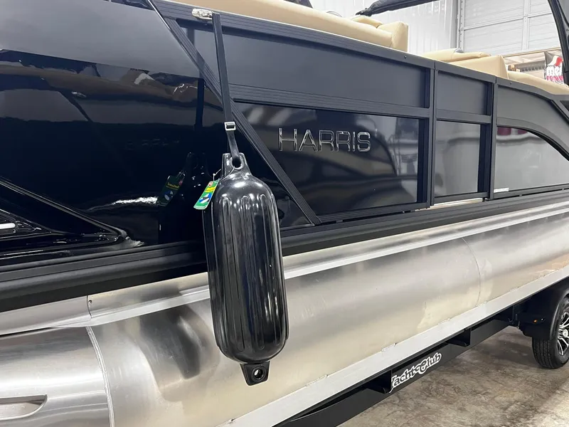 Slide: The Image of 2024 Harris 250 Grand Mariner V10 400 pontoon boat, black exterior, docked indoors. - 34