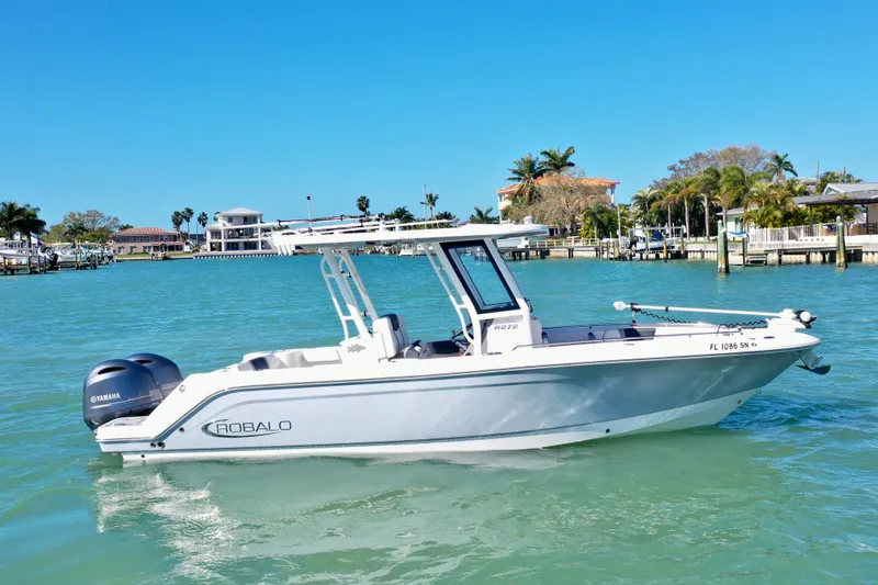 The Image of 2020 Robalo R272 Center Console boat on turquoise water near a tropical shoreline. - 0