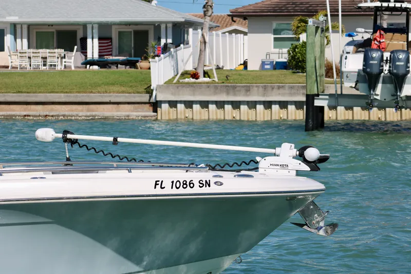 Slide: The Image of 2020 Robalo R272 Center Console boat with Minn Kota trolling motor in a marina setting. - 13