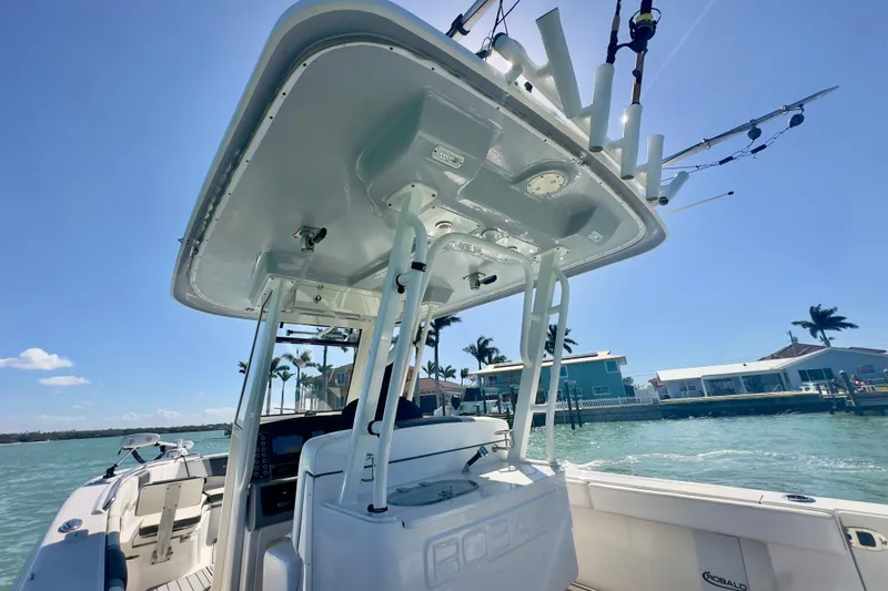 Slide: The Image of 2020 Robalo R272 Center Console boat on water, sunny day, palm trees in background. - 15