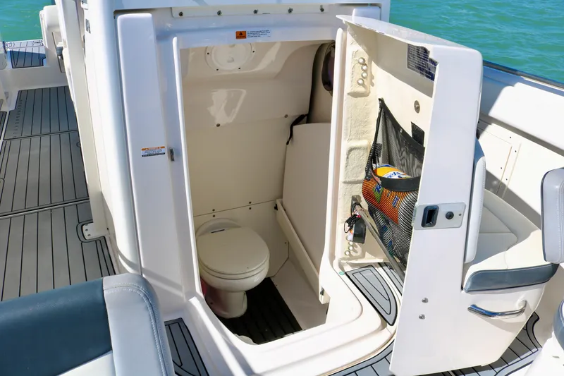 Slide: The Image of 2020 Robalo R272 Center Console boat interior with open bathroom compartment. - 19