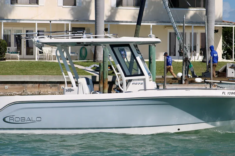 Slide: The Image of 2020 Robalo R272 Center Console boat docked near waterfront property. - 2