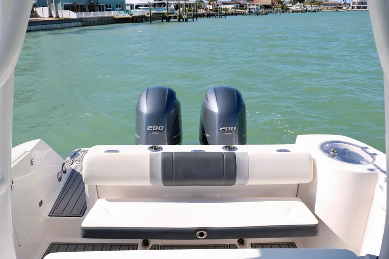 Slide: The Image of 2020 Robalo R272 Center Console boat with twin 200 horsepower engines on calm water. - 22