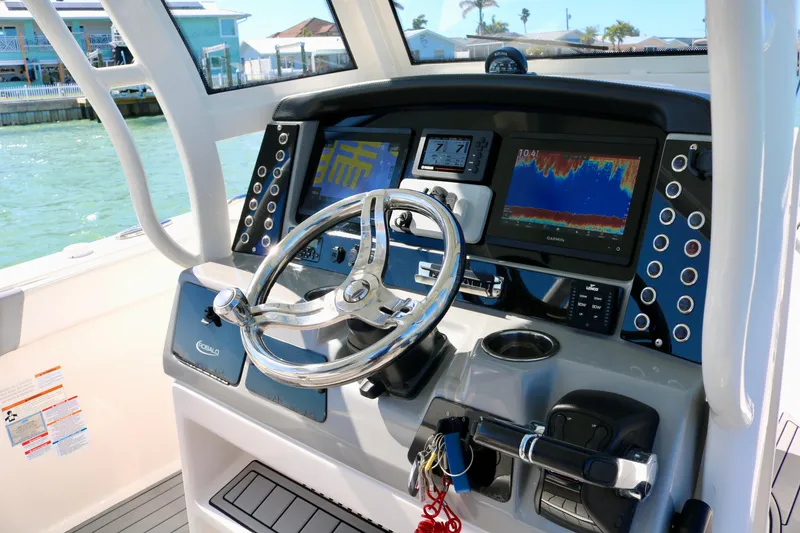 Slide: The Image of 2020 Robalo R272 Center Console boat dashboard with steering wheel and navigation displays. - 26