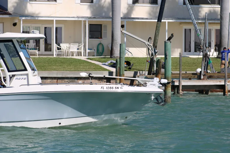Slide: The Image of 2020 Robalo R272 Center Console boat docked near waterfront home. - 3