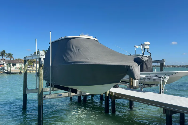 Slide: The Image of 2020 Robalo R272 Center Console boat covered and docked by the water. - 35