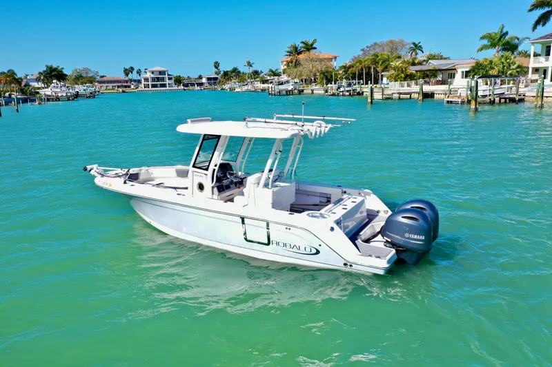 Slide: The Image of 2020 Robalo R272 Center Console boat on turquoise water near waterfront homes. - 7