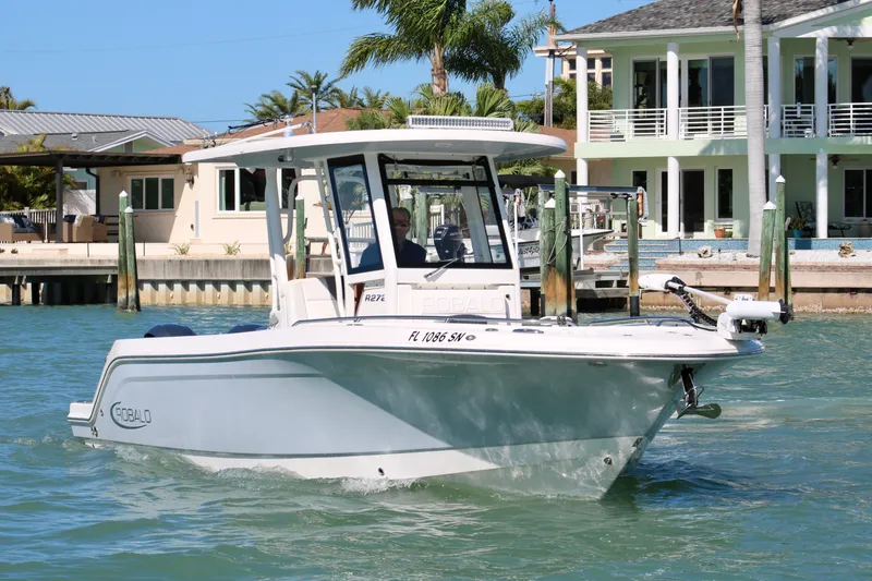 Slide: The Image of 2020 Robalo R272 Center Console boat cruising near waterfront homes. - 9