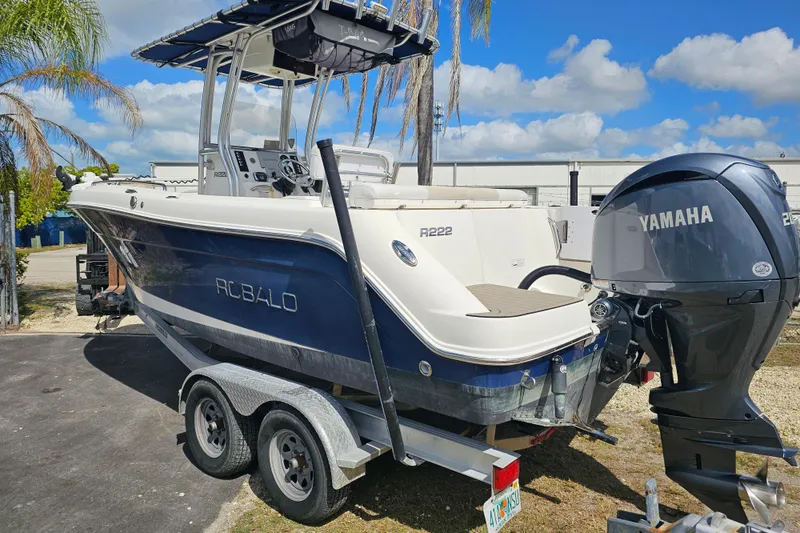 Slide: The Image of 2015 Robalo R222 Center Console boat with cushioned seating and outboard motor. - 14