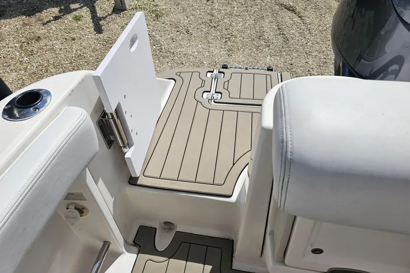 Slide: The Image of 2015 Robalo R222 Center Console storage compartment with open hatch and visible equipment. - 21