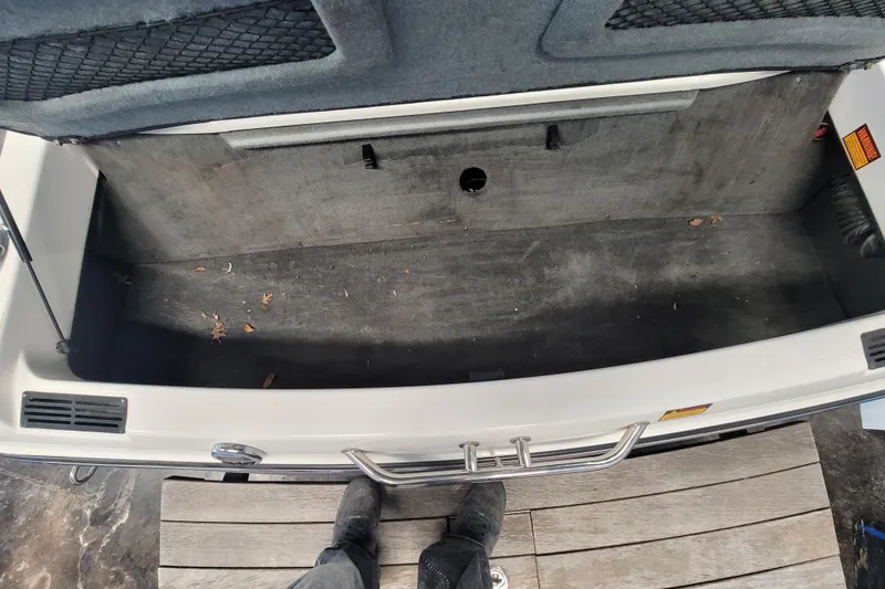 Slide: The Image of Open storage compartment of a 2003 Malibu Sunsetter LXi boat, showing interior space. - 10