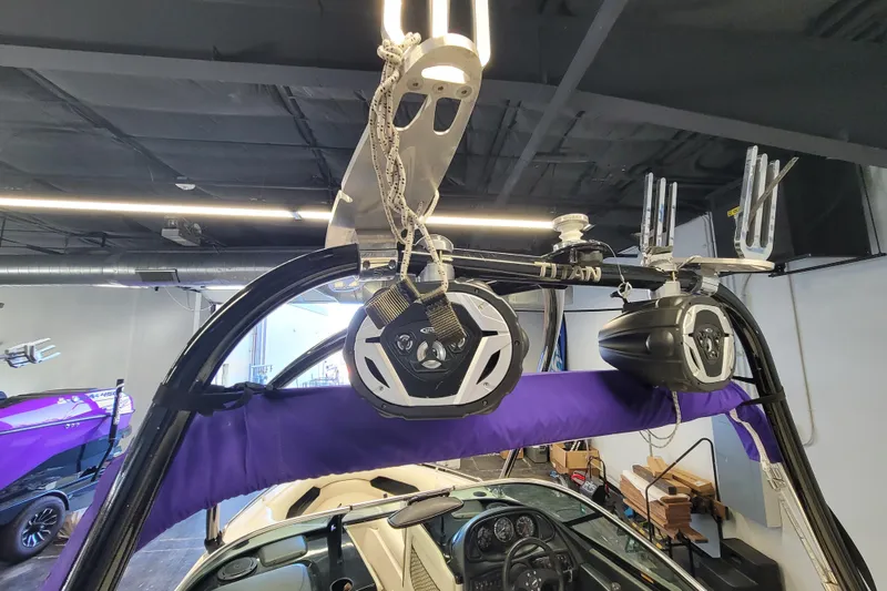 Slide: The Image of 2003 Malibu Sunsetter LXi boat with speakers and wakeboard tower in a garage. - 16