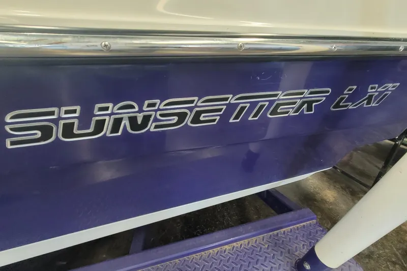 Slide: The Image of 2003 Malibu Sunsetter LXi boat with bold logo on blue hull. - 18