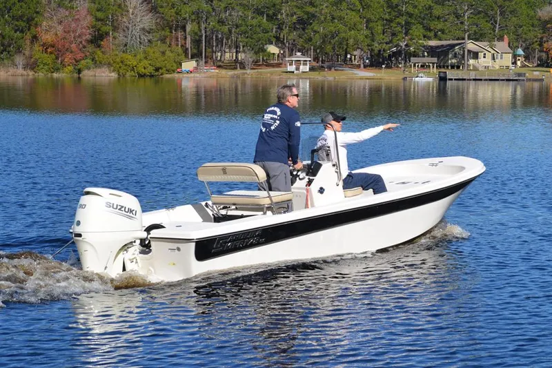 Slide: The Image of Manufacturer Provided Image: 2026 Carolina Skiff 178 JLS boat cruising on a serene lake with two passengers. - 11