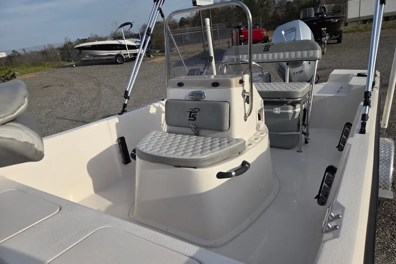 Slide: The Image of 2026 Carolina Skiff 178 JLS boat interior with seating and console, parked outdoors. - 20