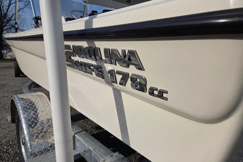 Slide: The Image of 2026 Carolina Skiff 178 JLS boat on trailer, close-up of logo and hull. - 22