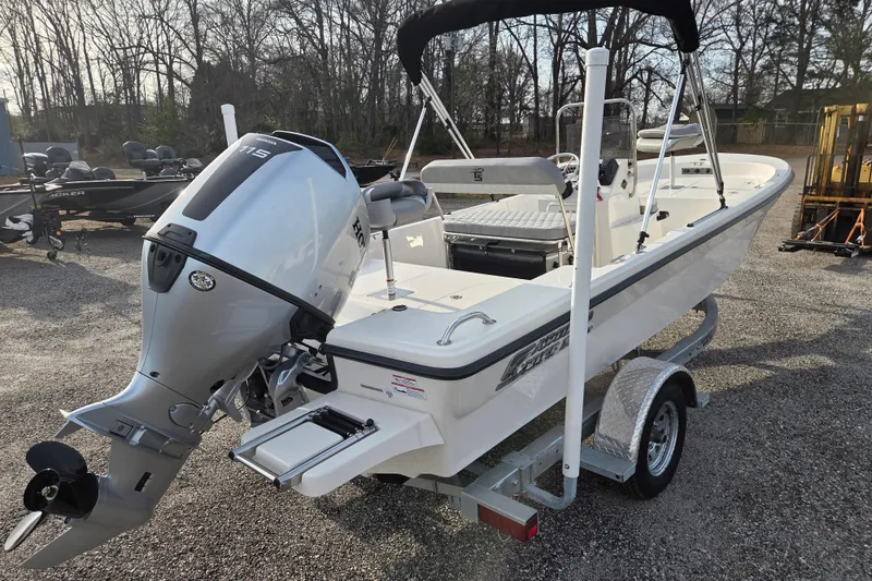 Slide: The Image of 2026 Carolina Skiff 178 JLS boat with outboard motor on trailer, parked outdoors. - 6