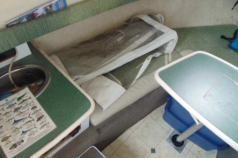 Slide: The Image of 2000 Bayliner 2302 Trophy Walkaround DX/LX cabin interior with table, sink, and fishing guide. - 18