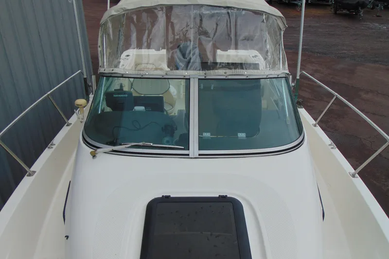 Slide: The Image of 2000 Bayliner 2302 Trophy Walkaround DX/LX boat with windshield and canopy, docked outdoors. - 24