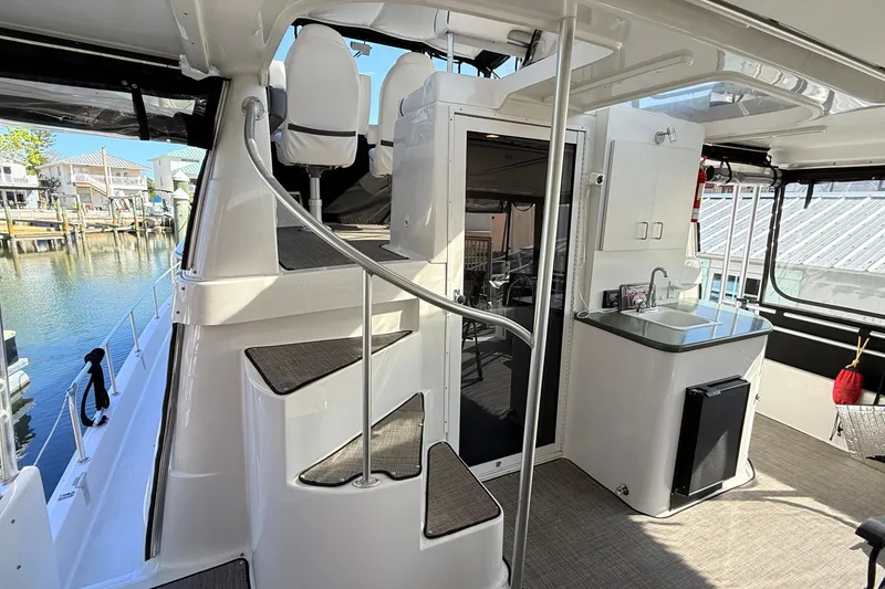 Slide: The Image of 1998 Mainship 47 Motor Yacht interior with spiral staircase and kitchenette. - 19