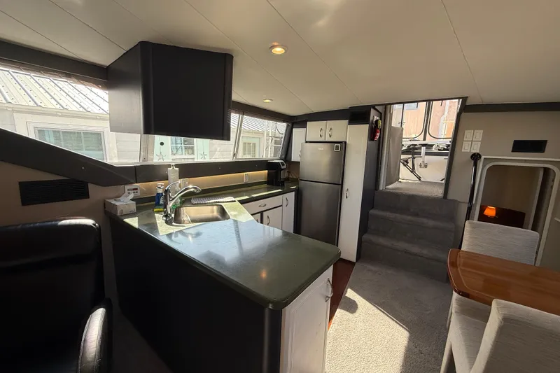 Slide: The Image of Interior of 1998 Mainship 47 Motor Yacht with modern kitchen and dining area. - 28