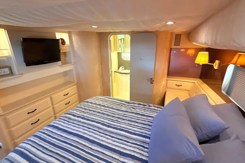 Slide: The Image of Cozy bedroom in 1998 Mainship 47 Motor Yacht with striped bedding and TV. - 44