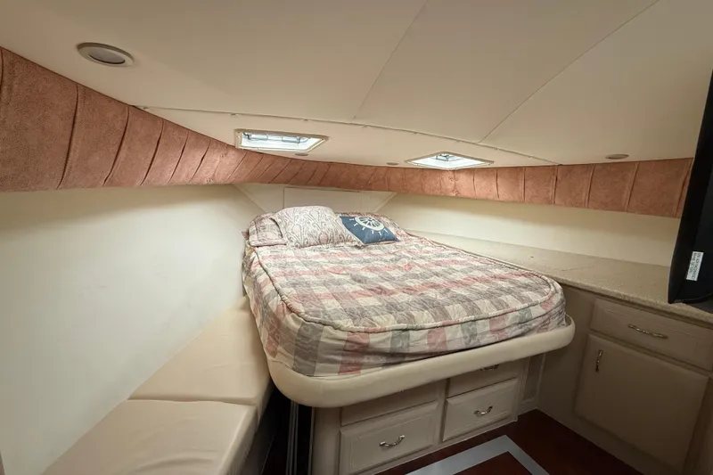 Slide: The Image of Cozy bedroom in 1998 Mainship 47 Motor Yacht with bed, storage, and natural light. - 57