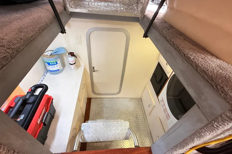 Slide: The Image of 1998 Mainship 47 Motor Yacht interior with storage, appliances, and safety equipment. - 61