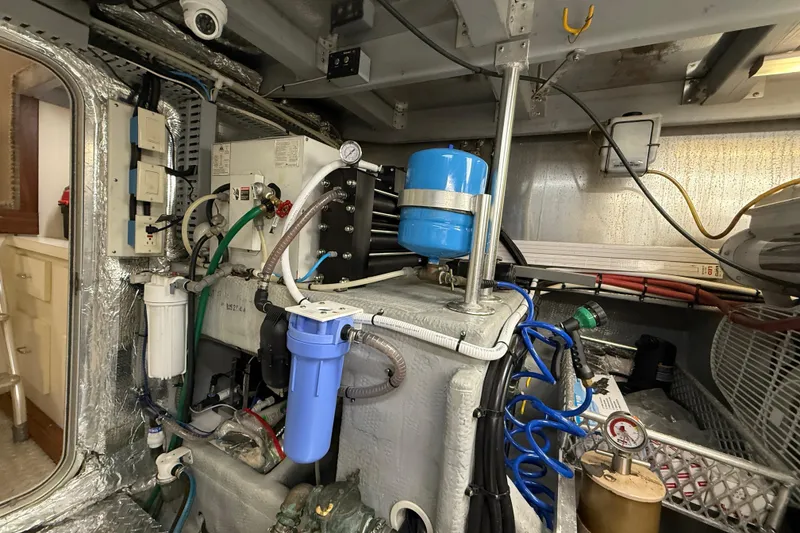 Slide: The Image of Engine room of a 1998 Mainship 47 Motor Yacht with various mechanical components. - 70