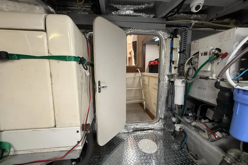 Slide: The Image of Engine room of 1998 Mainship 47 Motor Yacht with visible equipment and access door. - 71