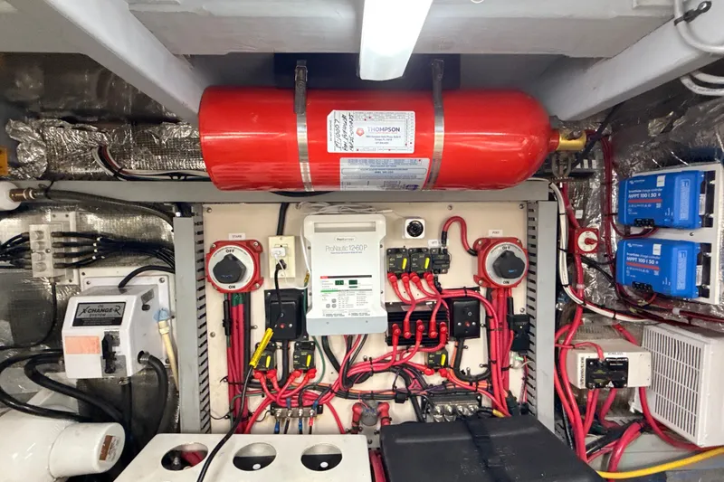 Slide: The Image of Engine room of 1998 Mainship 47 Motor Yacht with electrical systems and fire extinguisher. - 75