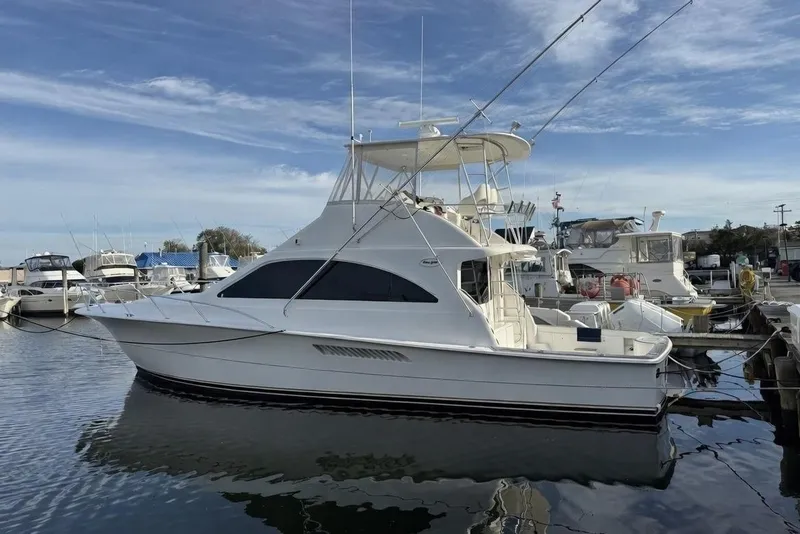The Image of 2005 Ocean Yachts 46 Super Sport docked at marina under blue sky. - 0