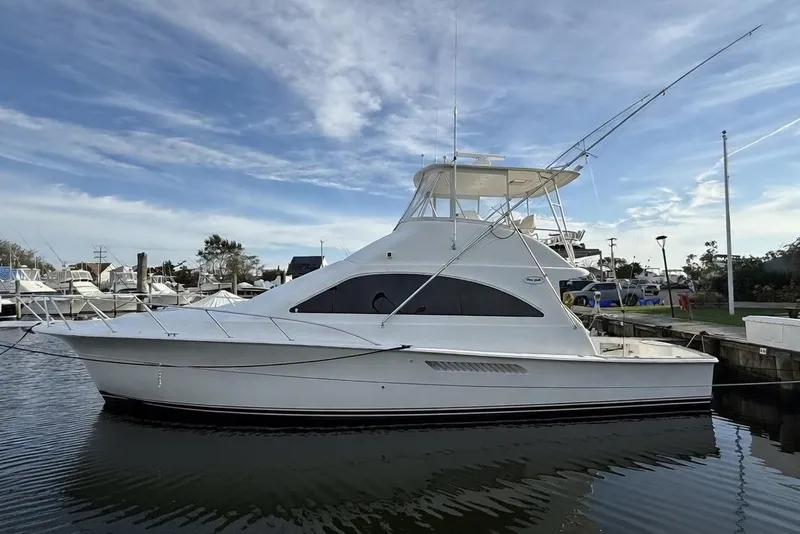 Slide: The Image of 2005 Ocean Yachts 46 Super Sport docked in a marina under a blue sky. - 2
