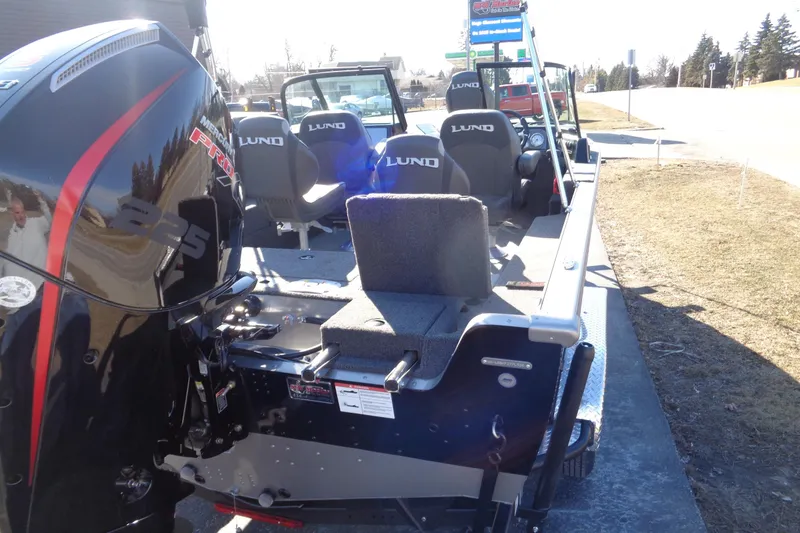 Slide: The Image of 2026 Lund 2075 Impact XS boat with Mercury Pro XS 225 engine, parked outdoors. - 10