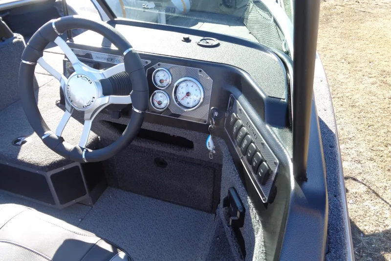 Slide: The Image of 2026 Lund 2075 Impact XS boat dashboard with steering wheel and control panel. - 18