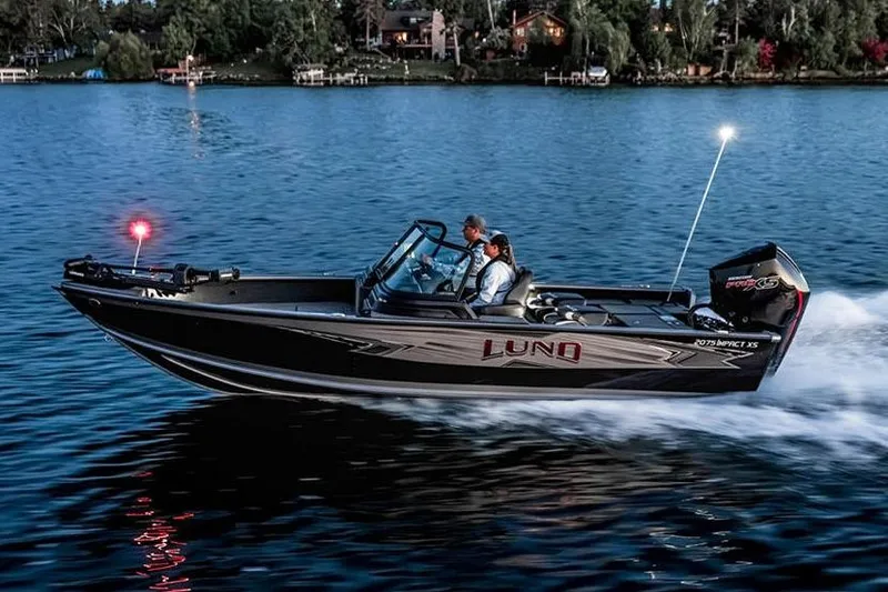 Slide: The Image of Manufacturer Provided Image: 2026 Lund 2075 Impact XS boat cruising on a serene lake at dusk. - 21