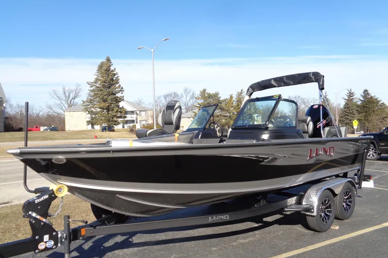 Slide: The Image of 2026 Lund 2075 Impact XS boat on trailer, parked outdoors under clear sky. - 7