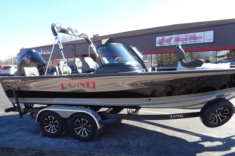 Slide: The Image of 2026 Lund 2075 Impact XS boat on trailer, parked outside a marine store. - 8