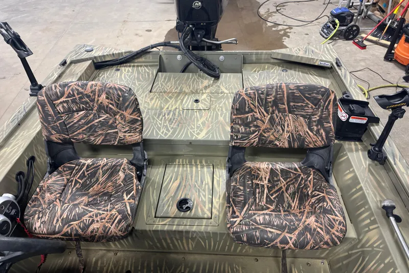 Slide: The Image of 2019 Tracker Grizzly 1754 MVX SC boat interior with camo seats and fishing equipment. - 12