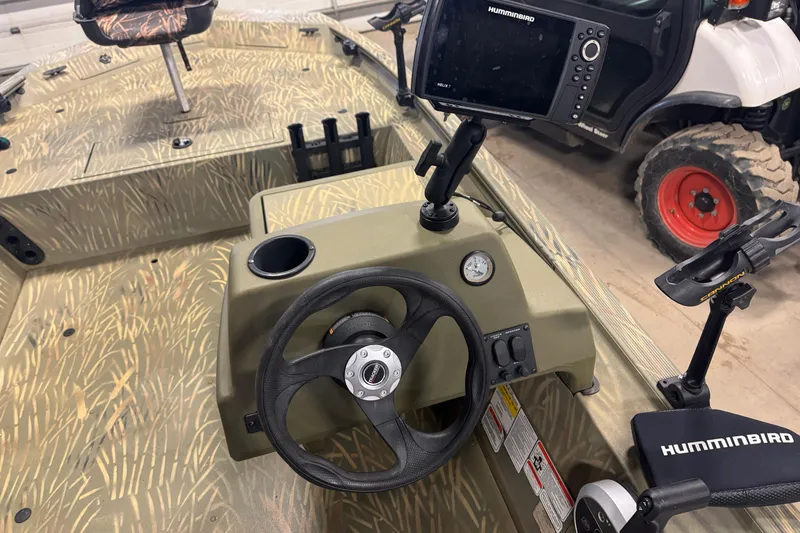Slide: The Image of 2019 Tracker Grizzly 1754 MVX SC boat interior with steering wheel and Humminbird fish finder. - 13