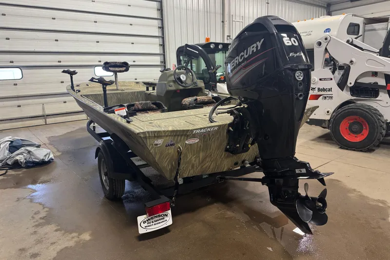 Slide: The Image of 2019 Tracker Grizzly 1754 MVX SC boat with Mercury 60 engine in a garage. - 2