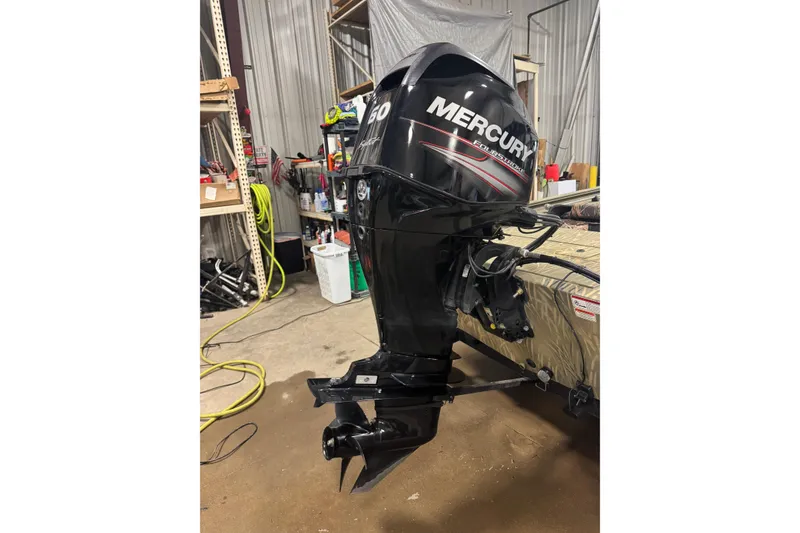 Slide: The Image of 2019 Tracker Grizzly 1754 MVX SC with Mercury outboard motor in a workshop setting. - 4