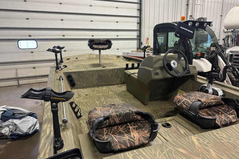 Slide: The Image of 2019 Tracker Grizzly 1754 MVX SC boat with camouflage seats in a garage. - 5