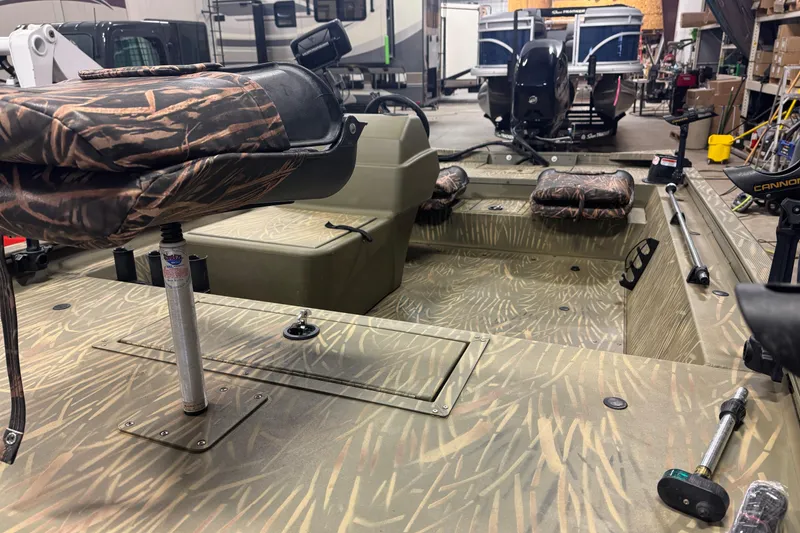 Slide: The Image of 2019 Tracker Grizzly 1754 MVX SC boat interior with camouflage seating and fishing equipment. - 6