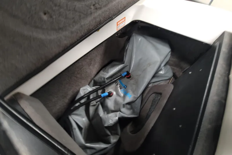 Slide: The Image of 2006 Malibu Wakesetter 23 LSV ballast compartment with gray bag and hoses. - 16