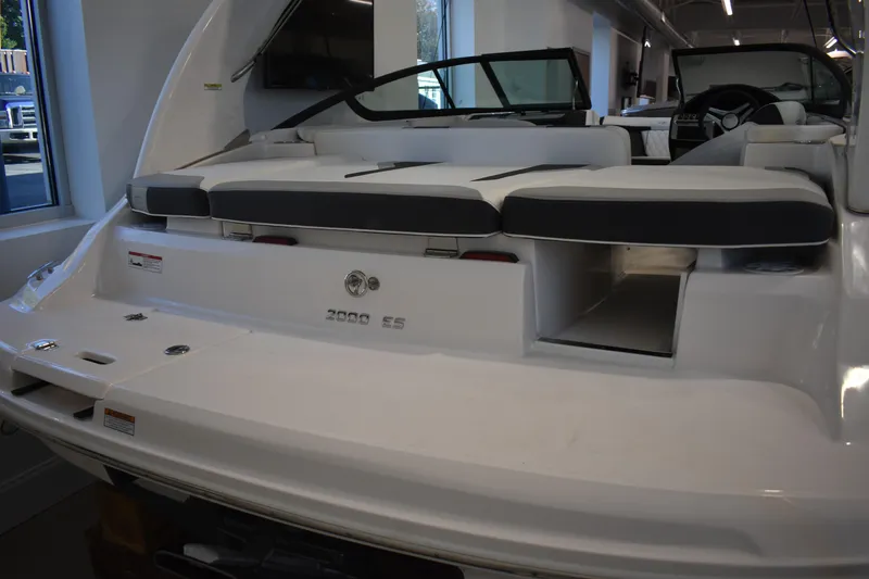 Slide: The Image of 2026 Regal 2000 ES boat interior with seating and storage, displayed indoors. - 2